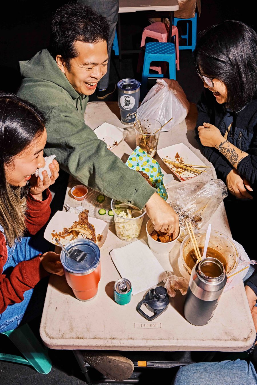 Friends laughing over food at DS Night Market