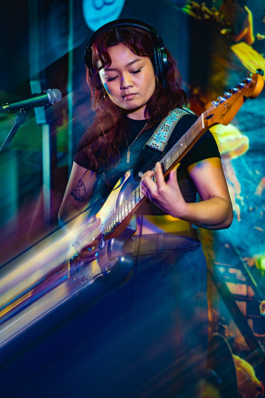 Performer playing guitar on stage at DS Night Market