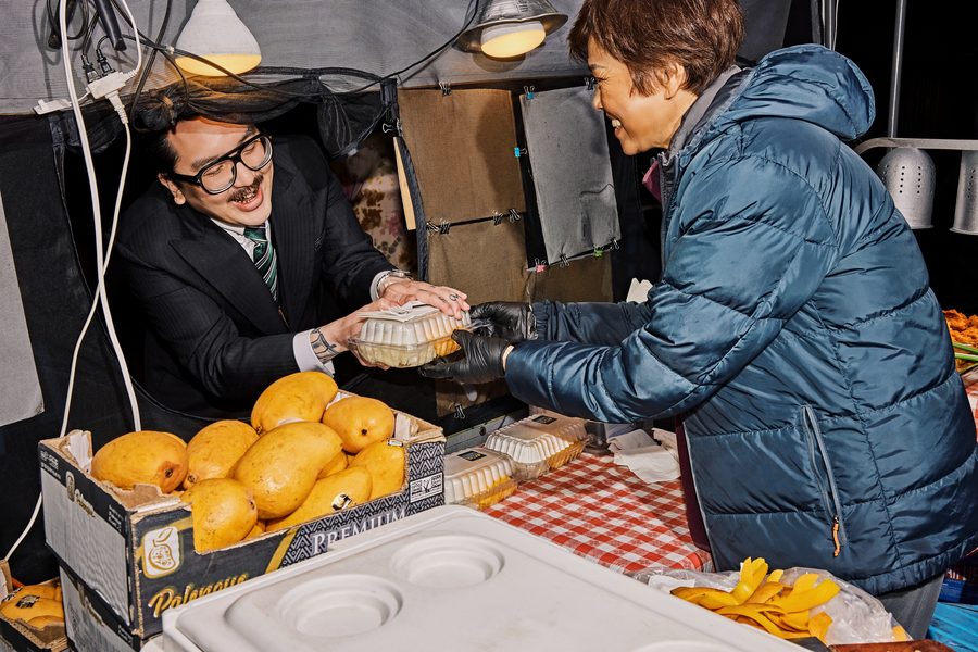 Vendor handing food to a happy customer at DS Night Market